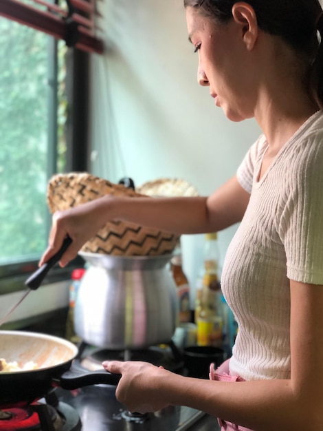 Photo side view of woman preparing food at home
