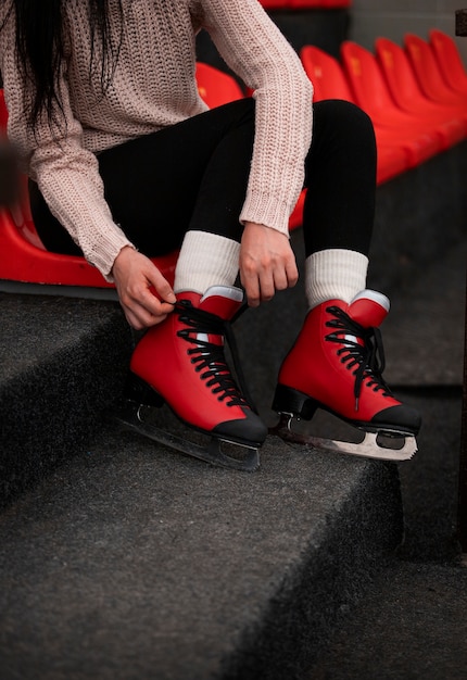 Side view woman putting on ice skates