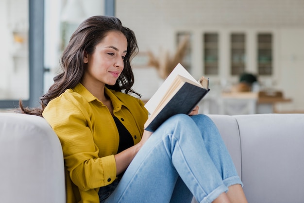 Side view woman reading indoors