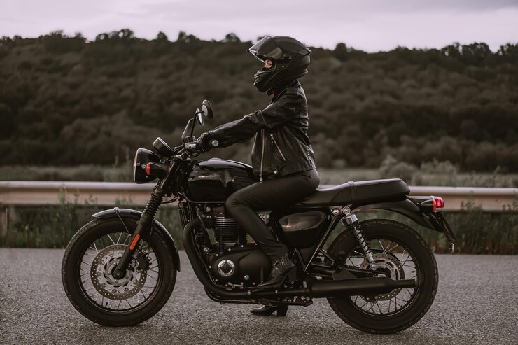Photo 道路でオートバイに乗っている女性のサイドビュー
