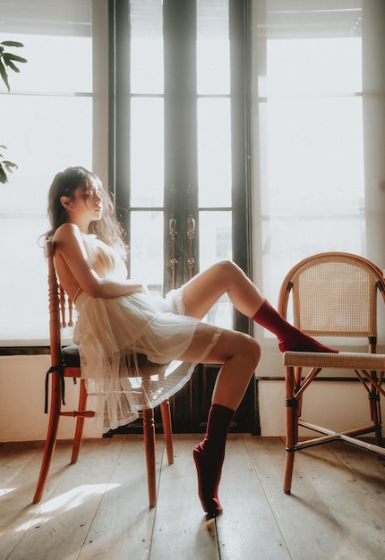 Side view of woman sitting on chairs at home