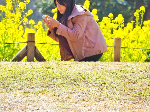 Side view of woman sitting on field