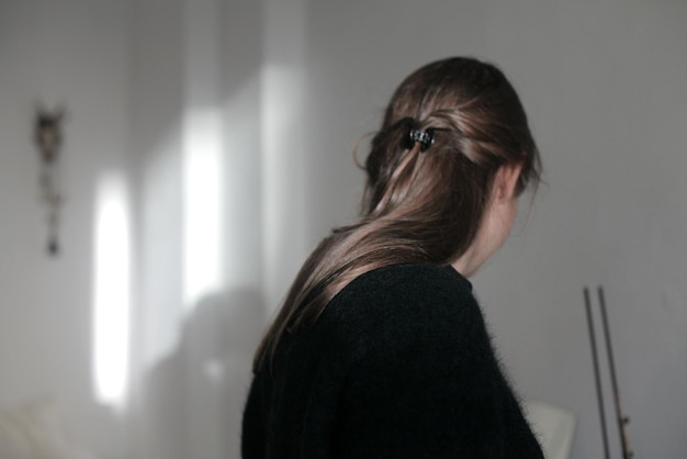 Side view of woman sitting at home