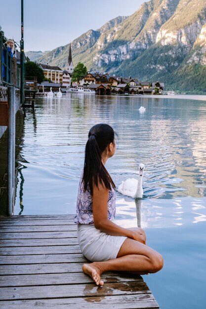 Photo side view of woman sitting on lake against mountain