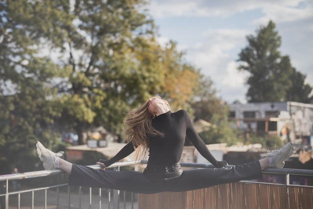 Photo side view of woman sitting on railing