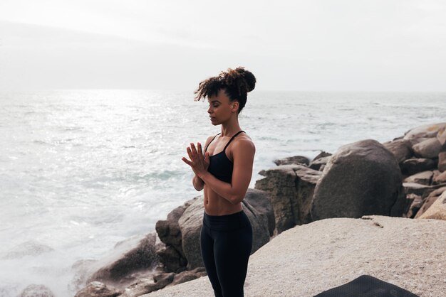 Photo side view of woman sitting on rock at beach