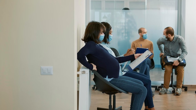 Photo side view of woman sitting on window