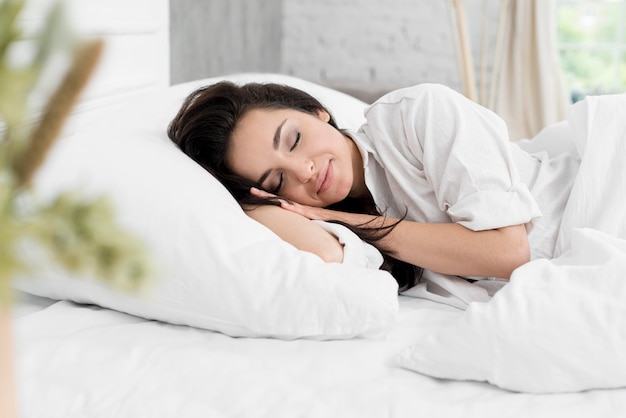 Vista laterale della donna che dorme nel letto