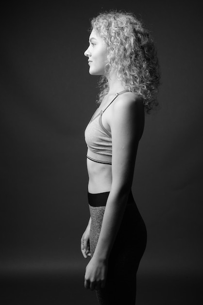 Photo side view of woman standing against black background