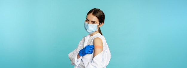 Side view of woman standing against blue background