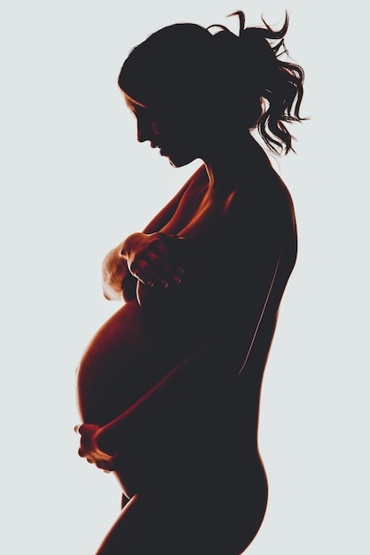 side view of woman standing against white background