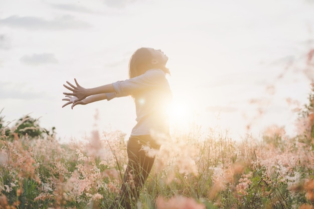 空の向こうの畑の花の中に立っている女性の横の景色