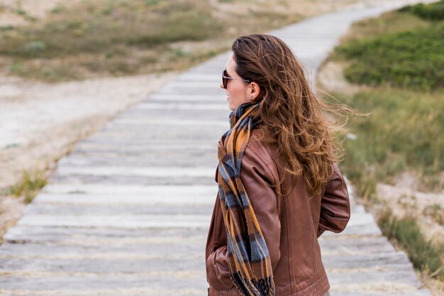 Photo side view of woman standing on boardwalk