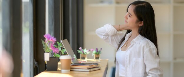 Photo side view of woman standing by potted plant on table