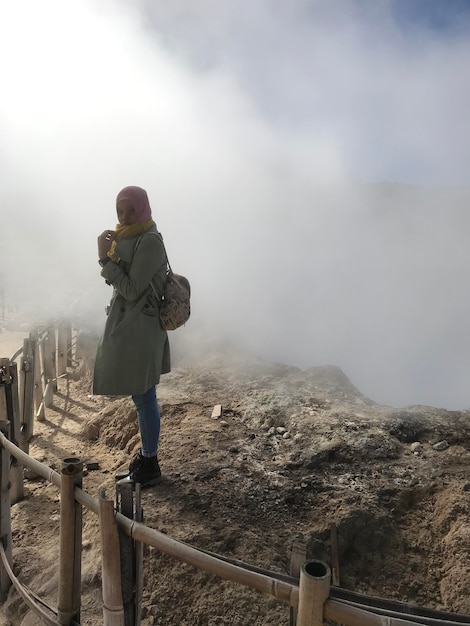 Foto vista laterale di una donna in piedi accanto a una ringhiera contro il cielo