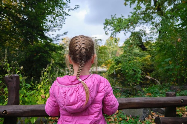 Side view of woman standing by railing against trees