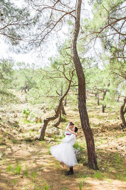 Side view of woman standing by tree in forest