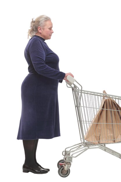 Side view of woman standing with shopping trolley with paper bags