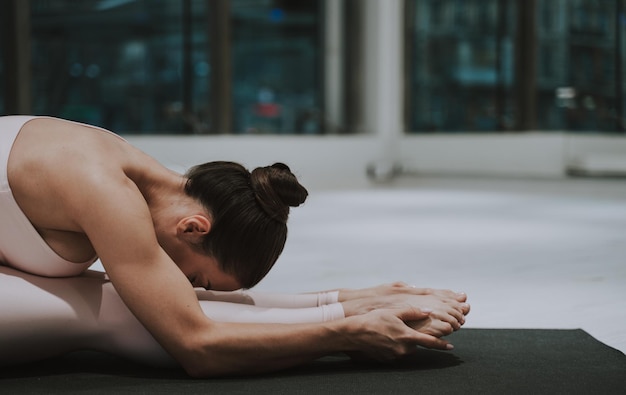 Photo side view of woman stretching at gym