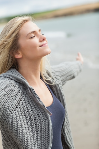 Photo side view of a woman stretching her arms on beach