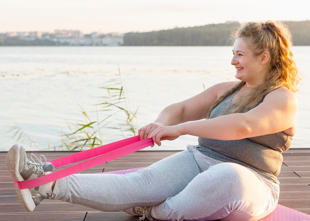 Side view of woman training with elastic band