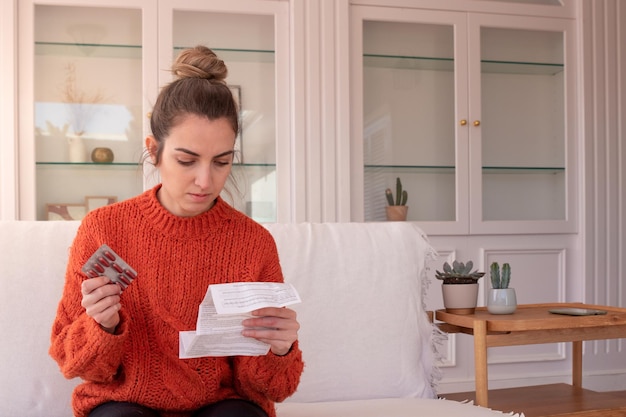 Side view of woman using digital tablet while sitting on sofa at home