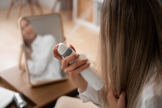 Photo side view woman using dry shampoo at home