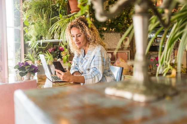 Foto vista laterale di una donna che usa un portatile in un caffè