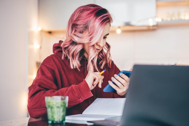 Photo side view of woman using laptop at home