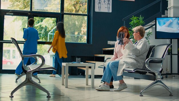 Photo side view of woman using mobile phone while sitting on table