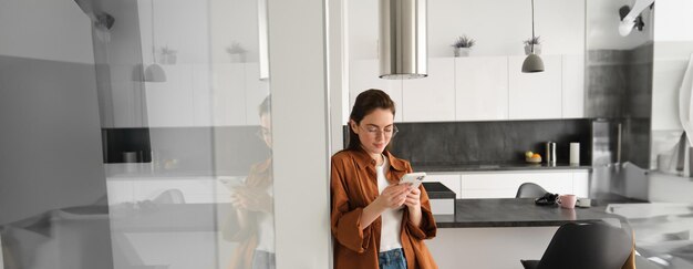 Foto vista laterale di una donna che usa il telefono cellulare mentre è in piedi in bagno