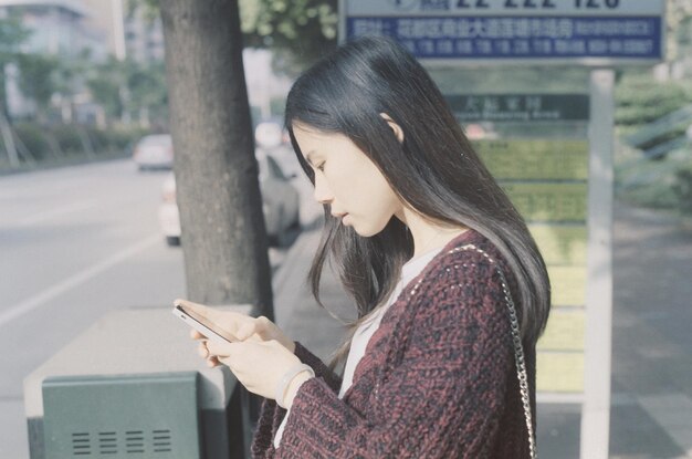 Side view of woman using mobile phone