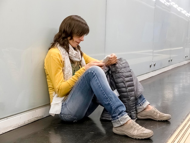 Foto vista laterale di una donna che usa un telefono cellulare