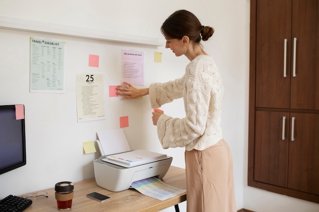 Side view woman using post its