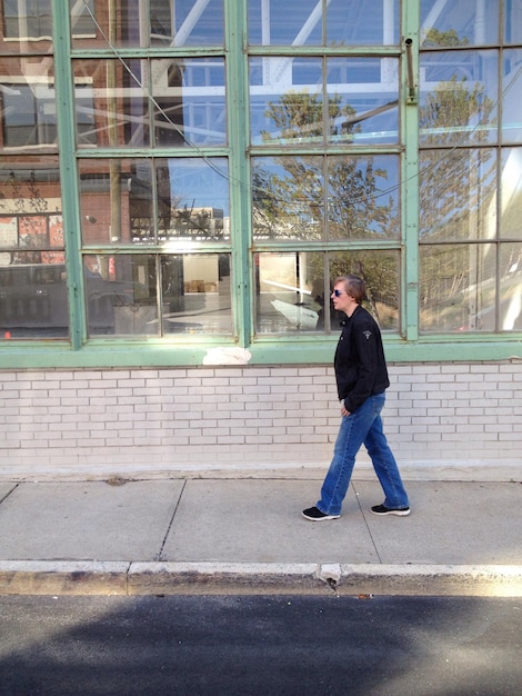 Photo side view of woman walking on sidewalk