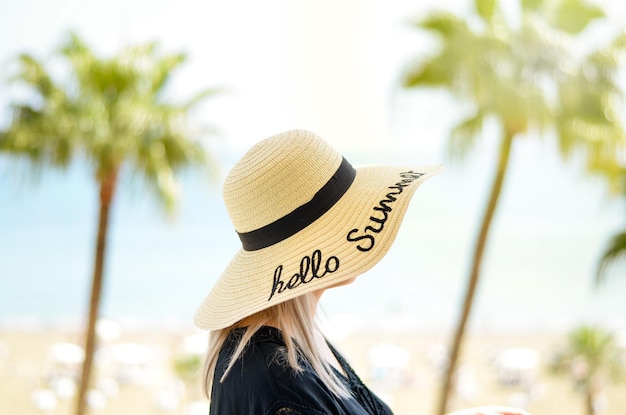 Photo side view of woman wearing hat with message against trees