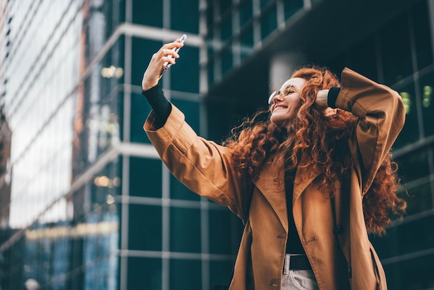 side view of woman with arms raised standing against building