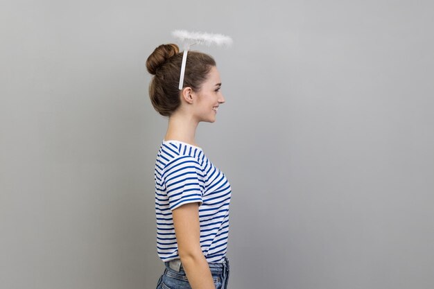 Photo side view of woman with nimbus over her head standing and looking ahead with positive expression