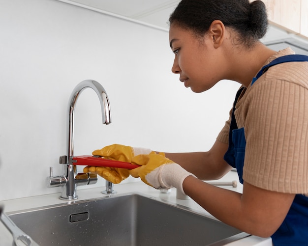 Photo side view woman working as plumber