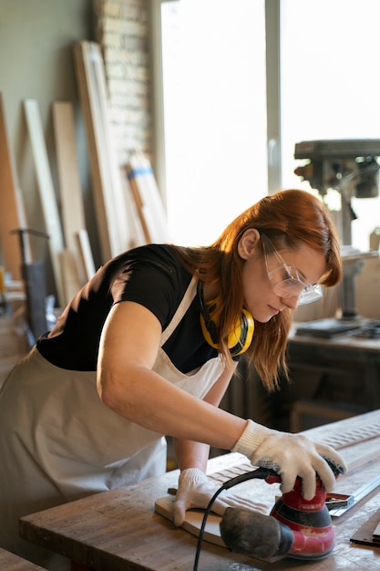 Foto donna di vista laterale che lavora in atelier