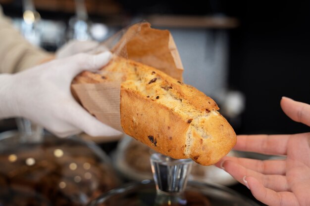 Foto donna di vista laterale che lavora in panetteria