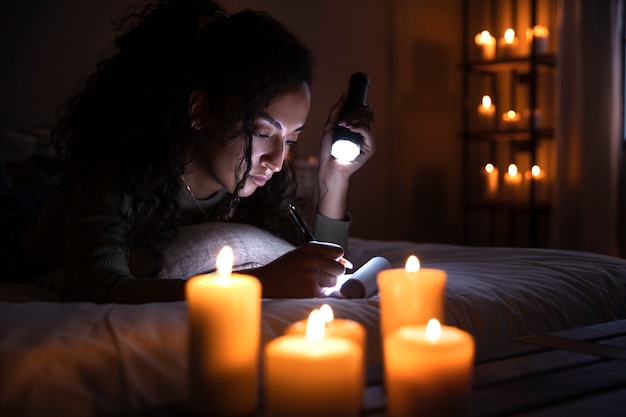 Side view woman writing with flashlight