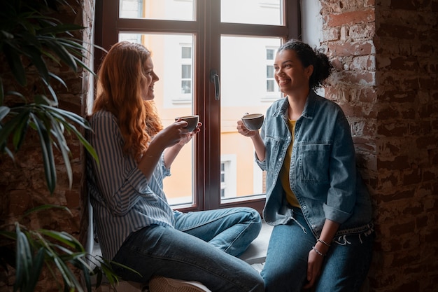 Photo side view women drinking coffee