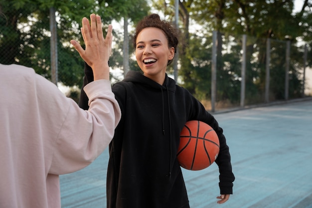 Foto donne di vista laterale che giocano a basket