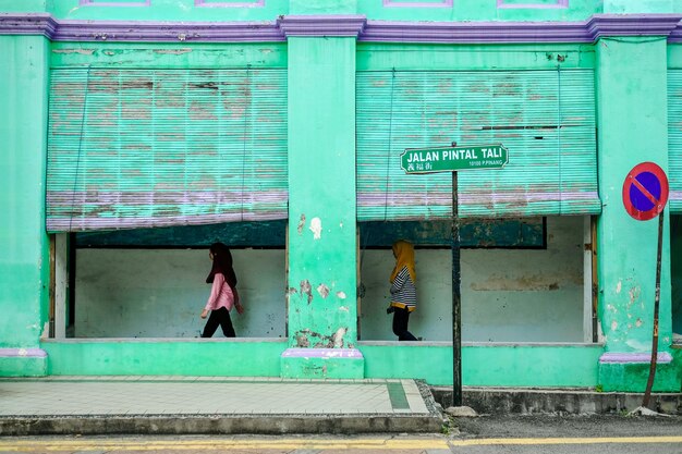 Photo side view of women walking on sidewalk