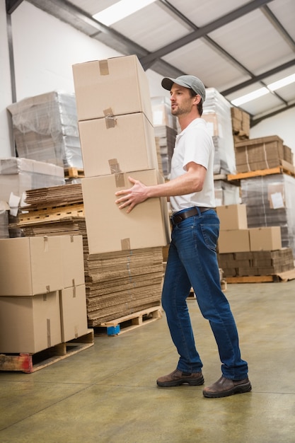 Side view of worker carrying boxes