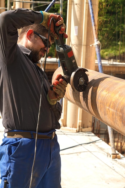 Side view of worker cutting metal with electric saw