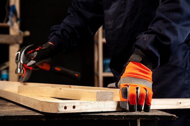 Photo side view worker holding hammer