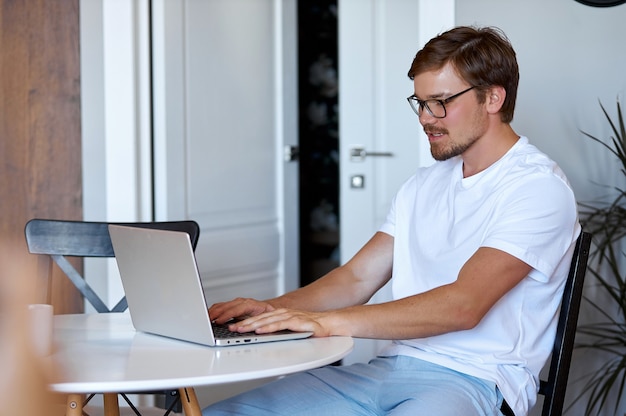 Vista laterale sull'uomo di lavoro con il computer portatile