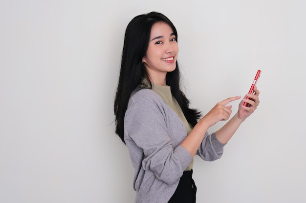 Side view of young Asian women smiling when touching her mobile phone